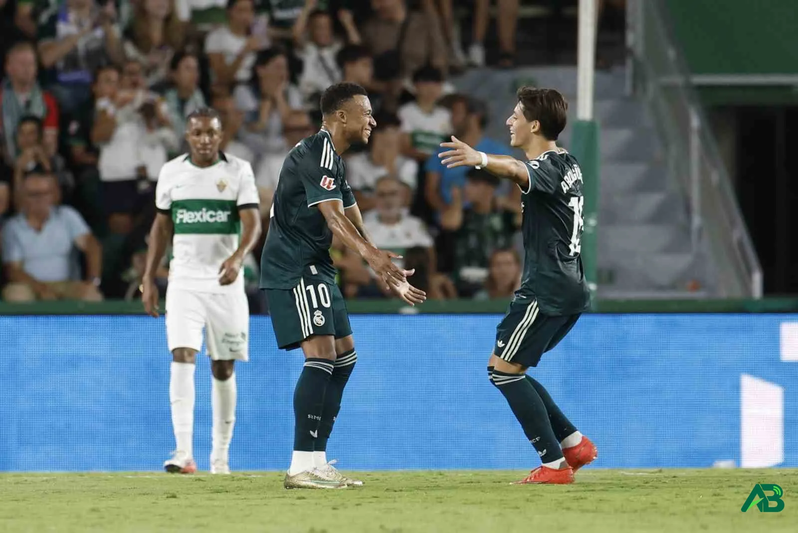 Real Madrid oyuncuları gol sevinci yaşarken sahada birbirlerine sarılıyor.