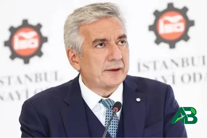 Lacivert takım elbiseli, mikrofon önünde konuşma yapan Erdal Bahçıvan.