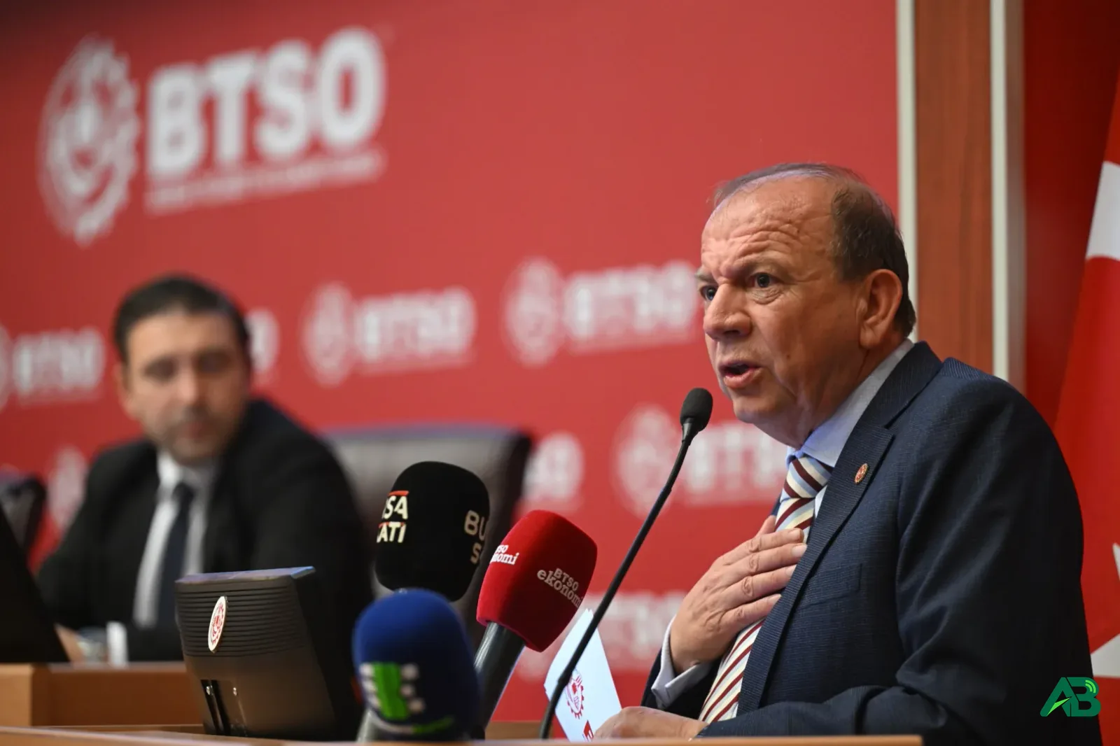 BTSO kürsüsünde konuşma yapan yetkili ve arkasında oturan katılımcı.