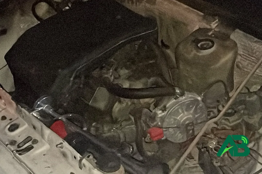 Otomobilin açık kaputu altında görünen motor bloğu ve parçaları.